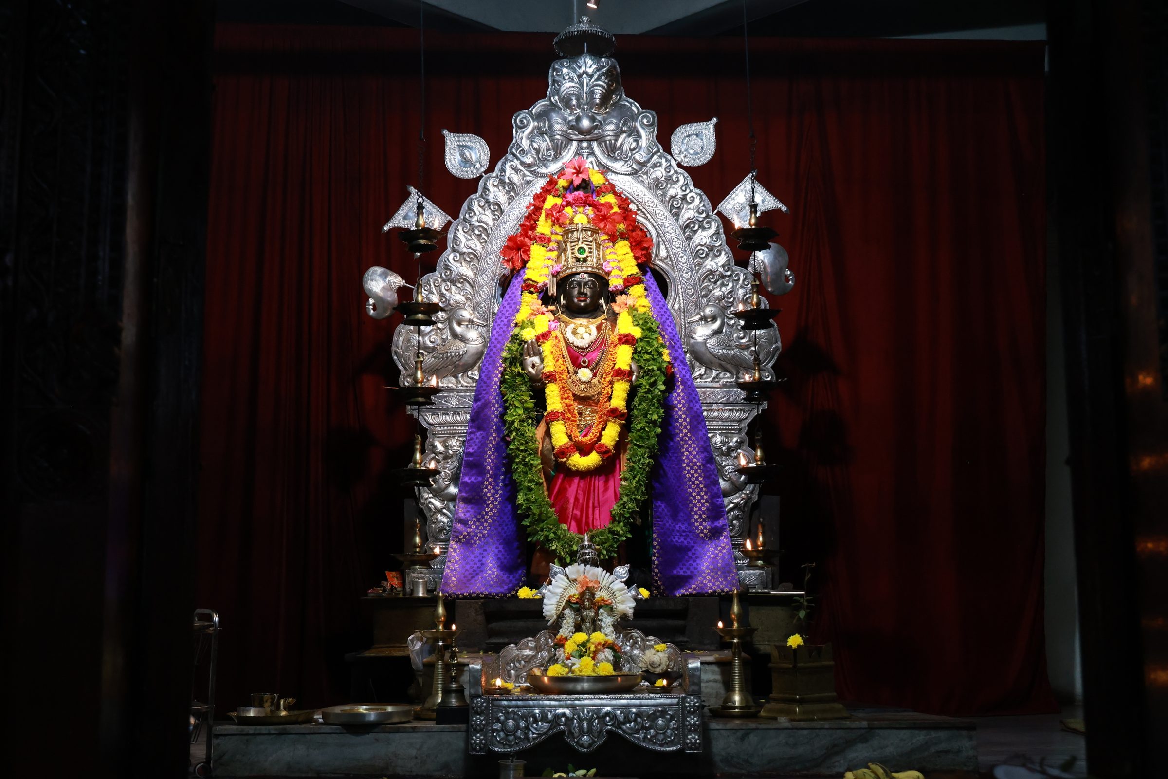 Devi Sree Ramambika in the sanctum, adorned with garlands beneath the silver prabhavali